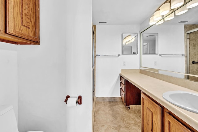 bathroom with vanity, toilet, tile patterned floors, and a shower with door