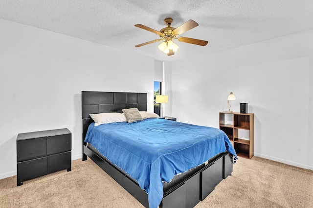 bedroom with a textured ceiling, light colored carpet, and ceiling fan