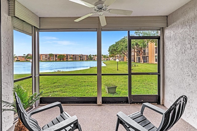 sunroom / solarium with a water view and ceiling fan