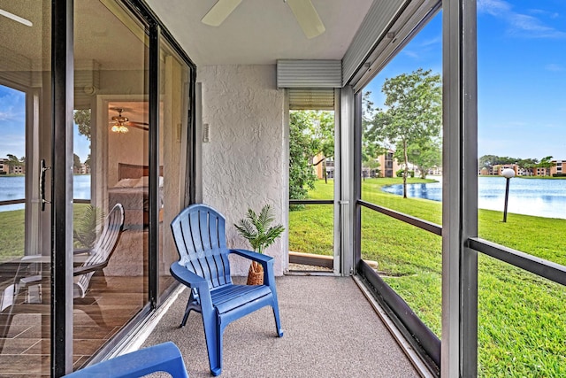 unfurnished sunroom with a water view and ceiling fan