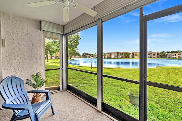 unfurnished sunroom with a water view and ceiling fan