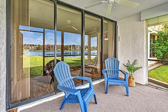 sunroom / solarium featuring a water view and ceiling fan