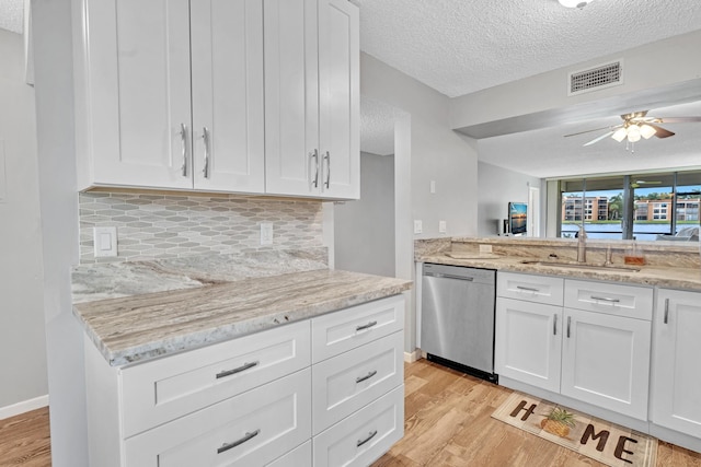 kitchen with light hardwood / wood-style flooring, dishwasher, white cabinets, and backsplash