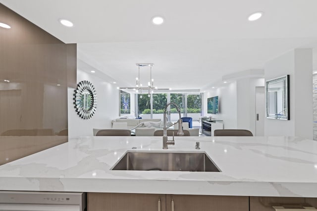 kitchen featuring white dishwasher, open floor plan, a sink, and recessed lighting