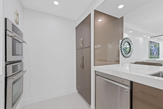 kitchen featuring recessed lighting, baseboards, open floor plan, appliances with stainless steel finishes, and modern cabinets