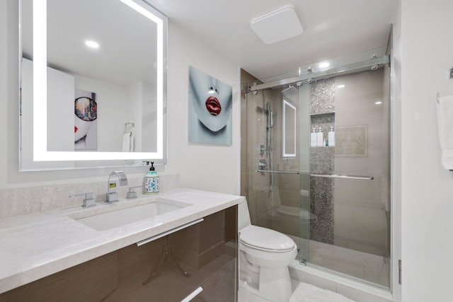 full bathroom featuring toilet, a stall shower, and vanity