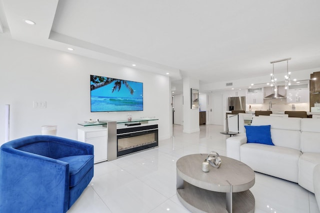 living room featuring light tile patterned floors, recessed lighting, visible vents, and a glass covered fireplace