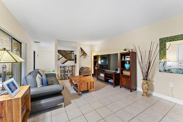 living room with a textured ceiling and light tile patterned floors