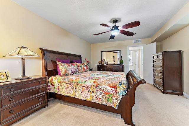 bedroom featuring light carpet, a textured ceiling, and ceiling fan