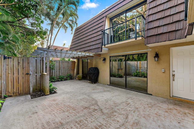 view of patio featuring a balcony and a pergola