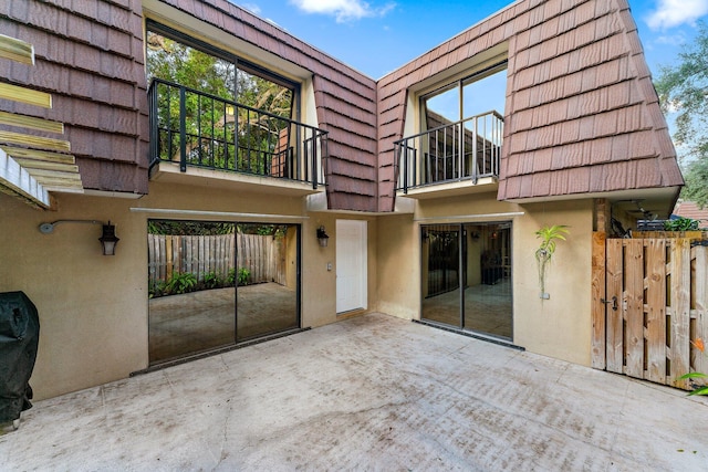 rear view of property with a balcony and a patio area