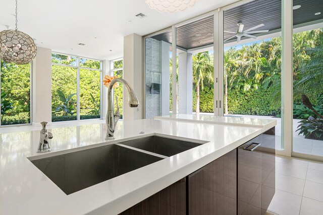 kitchen featuring pendant lighting, sink, light tile patterned flooring, and a wall of windows