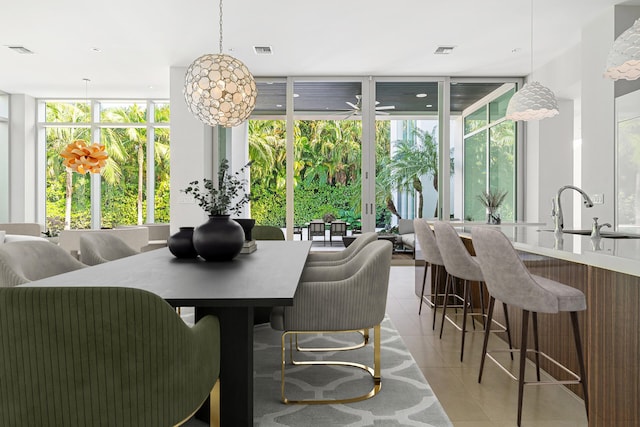 dining space with light tile patterned floors, sink, and floor to ceiling windows