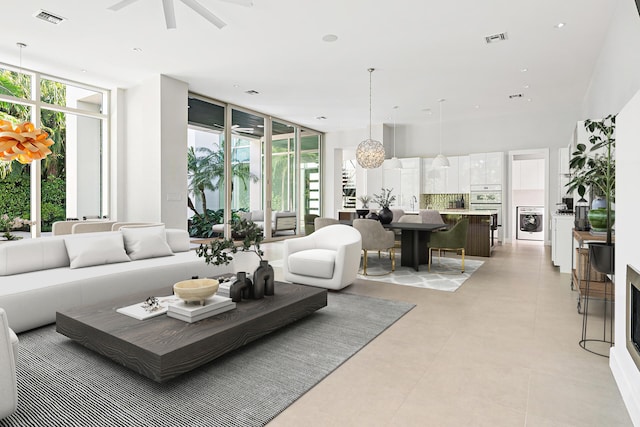 living room with a wealth of natural light, floor to ceiling windows, and ceiling fan