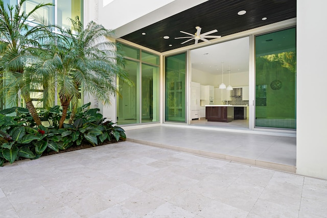 doorway to property featuring a patio, sink, and ceiling fan