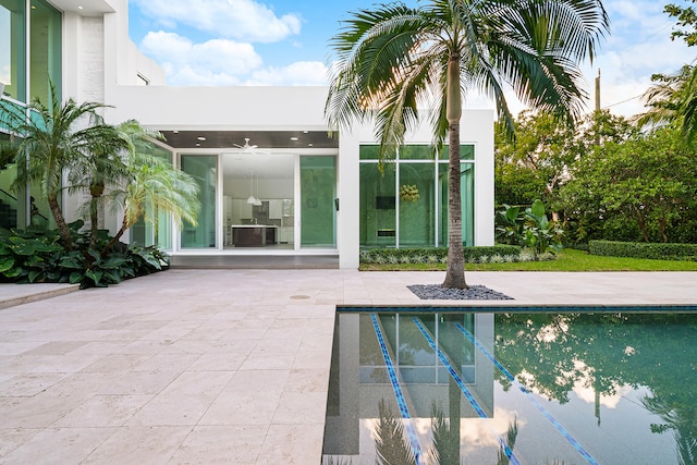 view of swimming pool featuring central AC unit, ceiling fan, and a patio