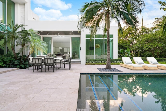 view of swimming pool with ceiling fan and a patio