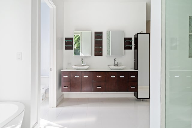 bathroom featuring toilet, vanity, and tile patterned floors