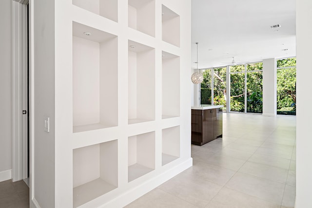 hall featuring a wall of windows and light tile patterned floors