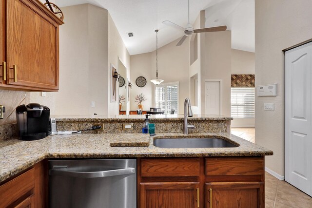 kitchen featuring light stone counters, high vaulted ceiling, sink, and stainless steel dishwasher