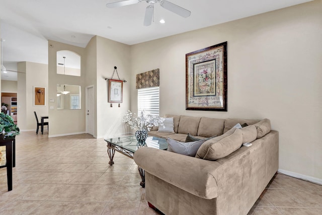 living room featuring a high ceiling, ceiling fan, and light tile patterned floors