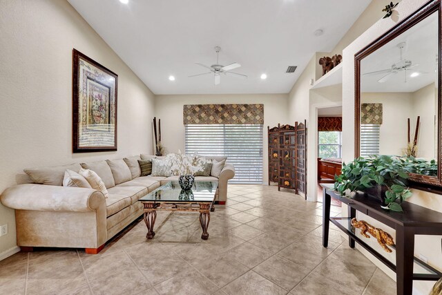 living room featuring lofted ceiling, ceiling fan, and a wealth of natural light