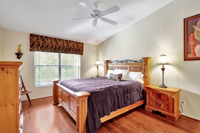 bedroom featuring hardwood / wood-style floors, vaulted ceiling, and ceiling fan