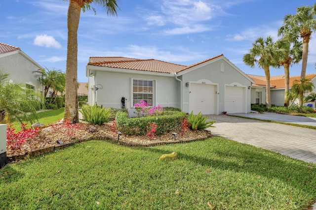 8503 Logia Cir, Boynton Beach, FL 33472 - mediterranean / spanish-style home featuring a garage, stucco siding, a tile roof, a front lawn, and driveway