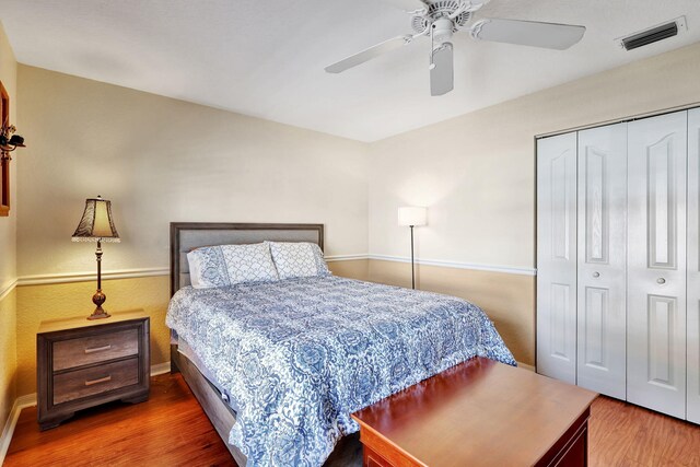 bedroom with dark wood-type flooring, a closet, and ceiling fan