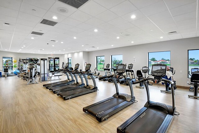 exercise room featuring light hardwood / wood-style flooring and a paneled ceiling