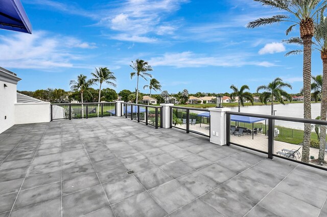 view of patio with a water view and a balcony