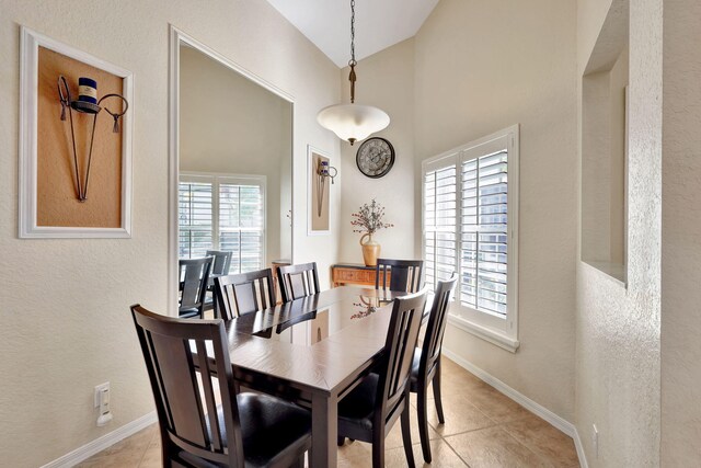 dining room featuring high vaulted ceiling, light tile patterned floors, and plenty of natural light