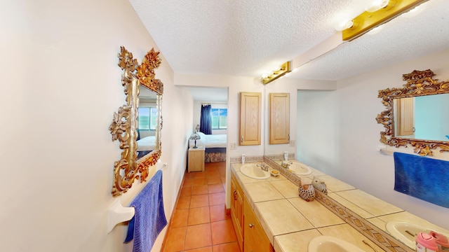 bathroom with tile patterned floors, vanity, and a textured ceiling