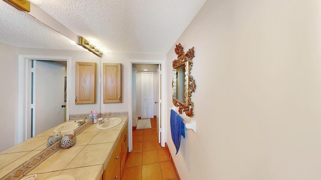 bathroom with tile patterned flooring, vanity, and a textured ceiling