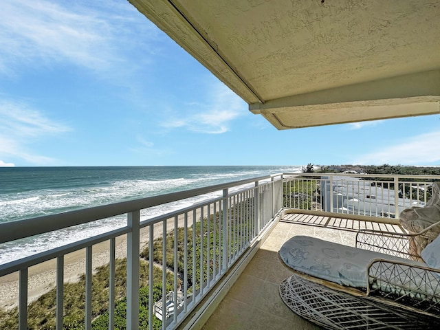 balcony featuring a water view and a beach view