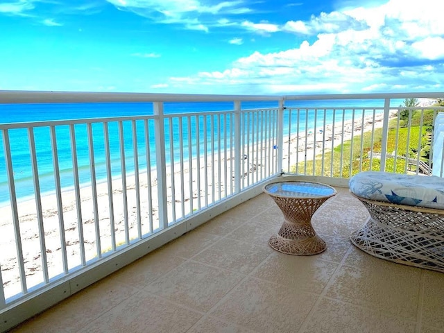 balcony featuring a water view and a beach view