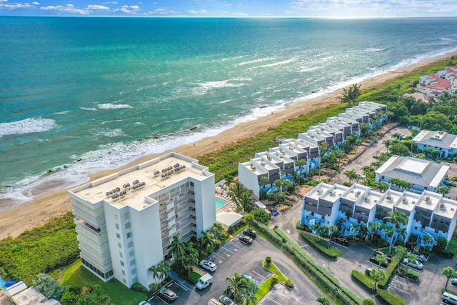 drone / aerial view with a water view and a beach view