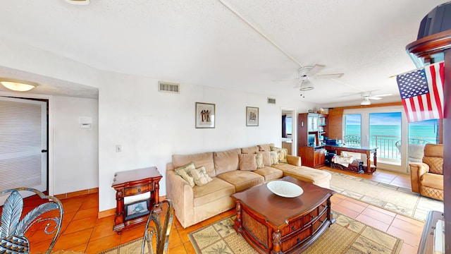 tiled living room with a textured ceiling and ceiling fan