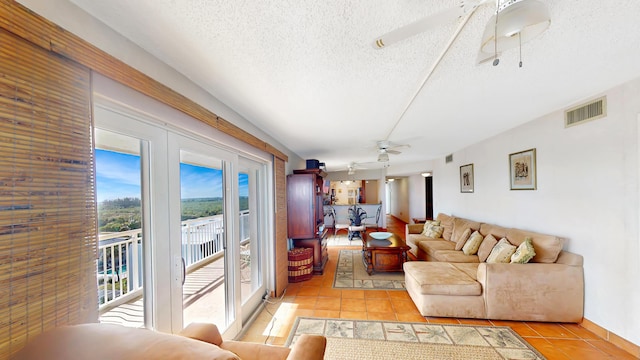 tiled living room with a textured ceiling and ceiling fan