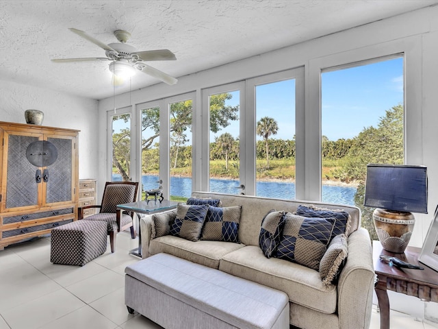 sunroom / solarium featuring a wealth of natural light, a water view, and ceiling fan