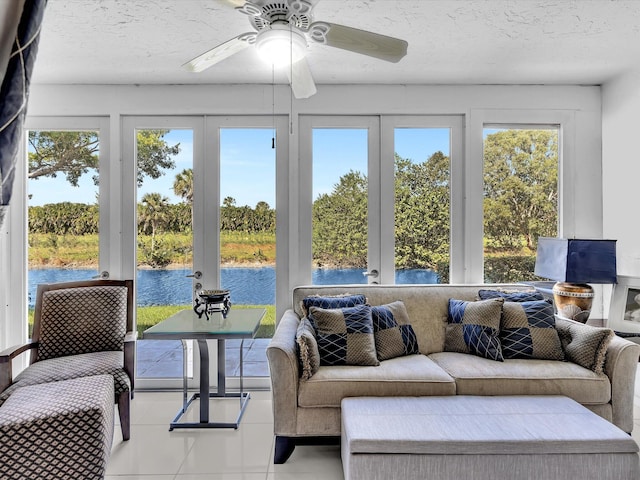 sunroom featuring a water view, a healthy amount of sunlight, and ceiling fan