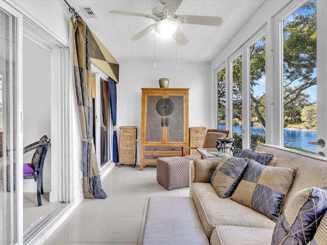 sunroom / solarium featuring a water view and ceiling fan