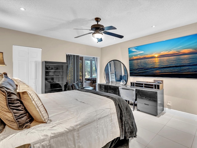 bedroom with a closet, a textured ceiling, light tile patterned floors, and ceiling fan