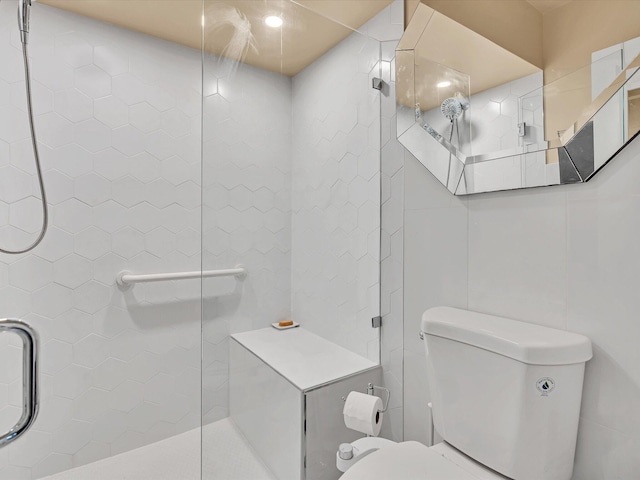 bathroom with a shower with door and toilet