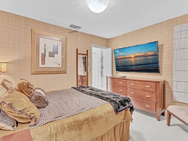 bedroom with a textured ceiling and light tile patterned floors