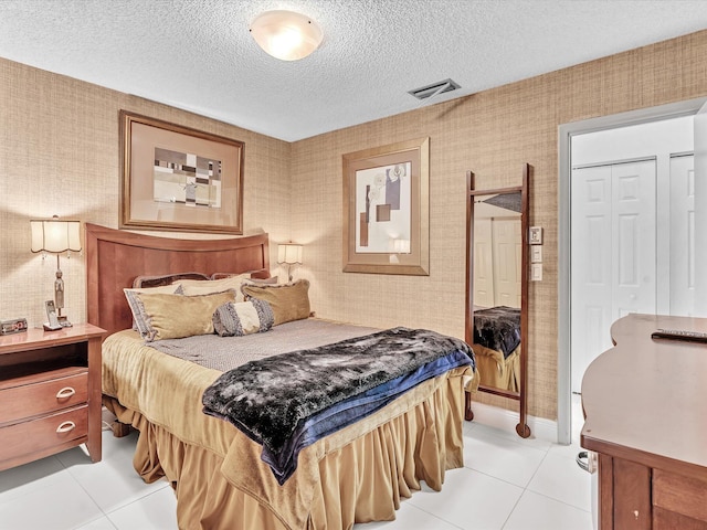 bedroom featuring a textured ceiling and light tile patterned flooring