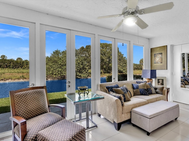 sunroom featuring a water view, ceiling fan, and a healthy amount of sunlight