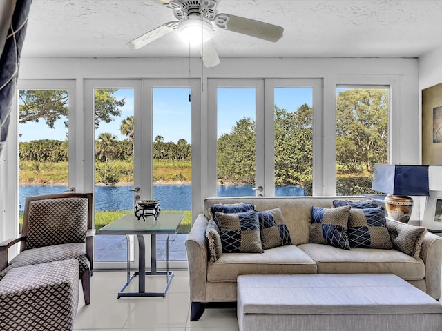 sunroom / solarium featuring french doors, ceiling fan, a water view, and plenty of natural light