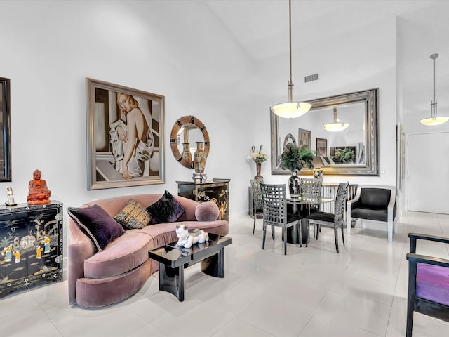 living room featuring a towering ceiling and light tile patterned floors