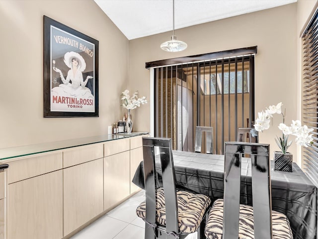 tiled dining area with vaulted ceiling